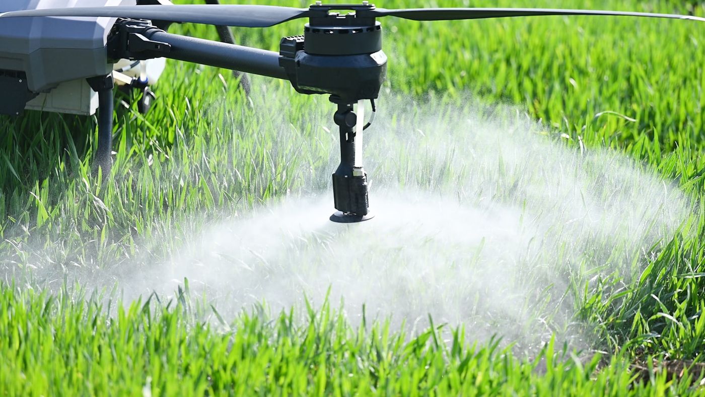Close-up of an industrial drone rotor arm and spray system in operation