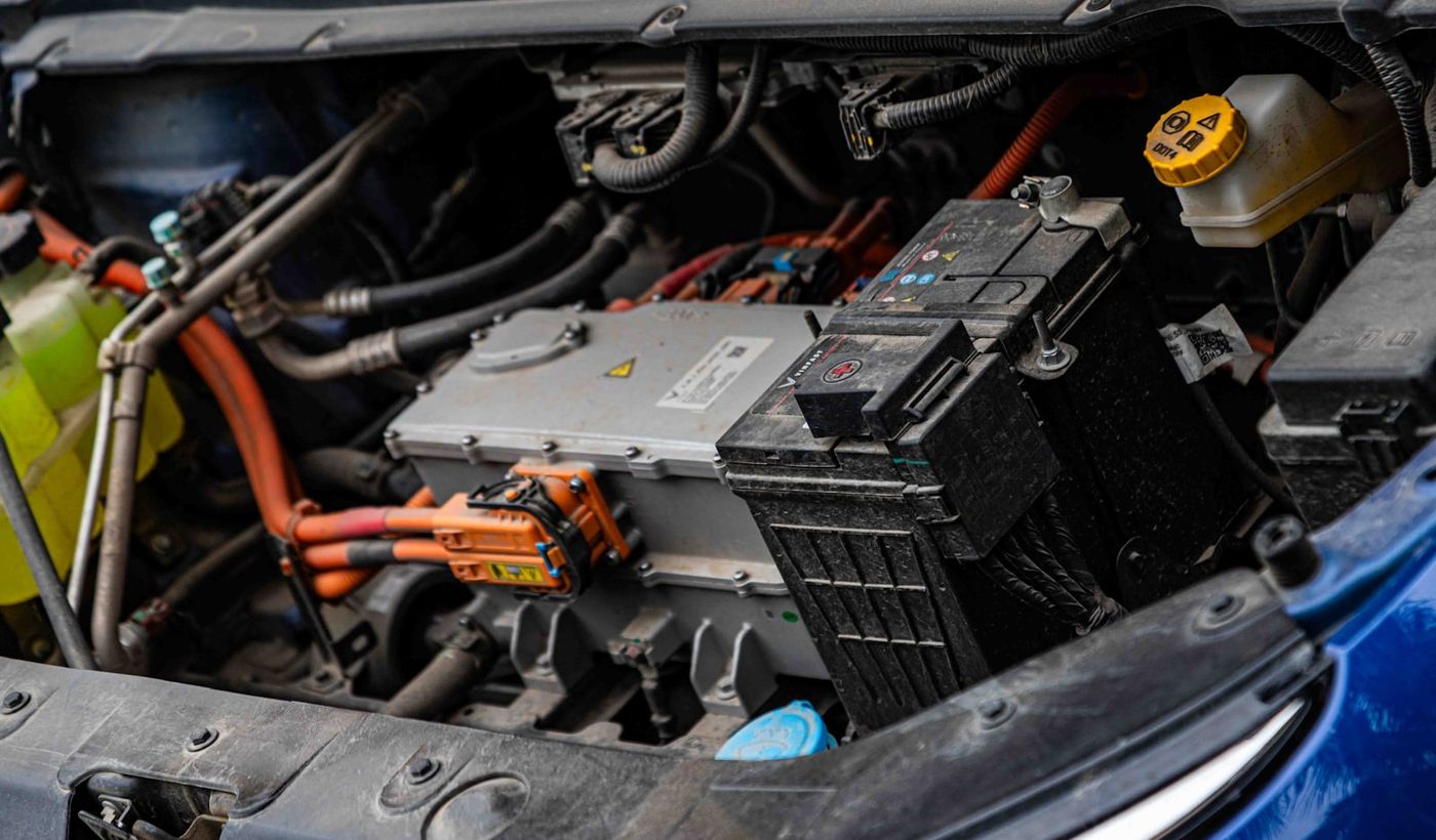 EV engine bay with high-voltage orange cabling and power electronics