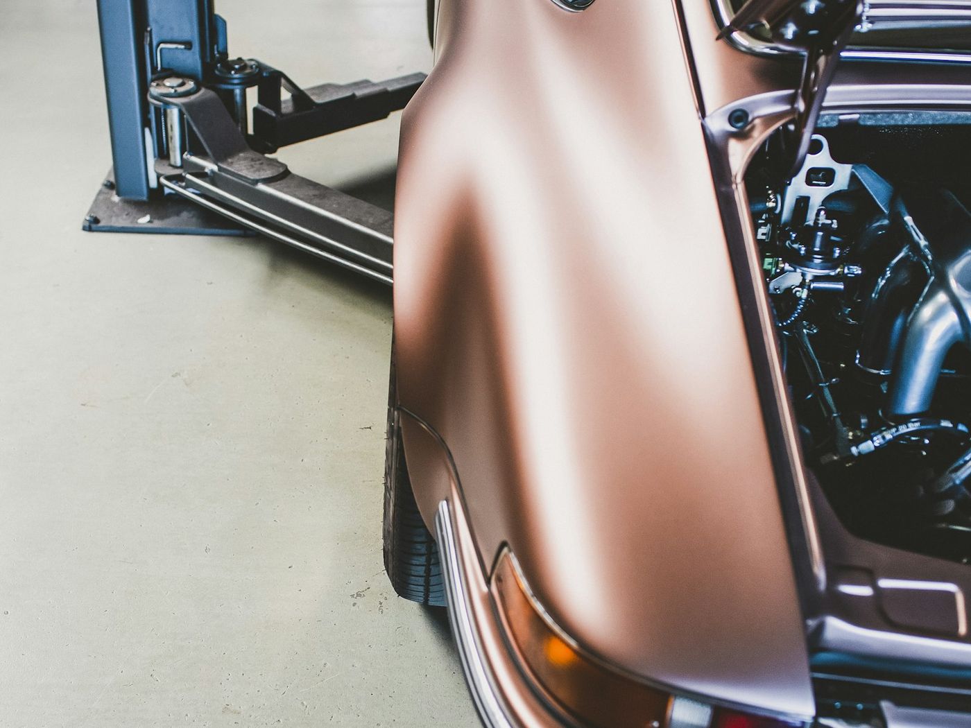 Classic sports car on a workshop lift with engine bay exposed
