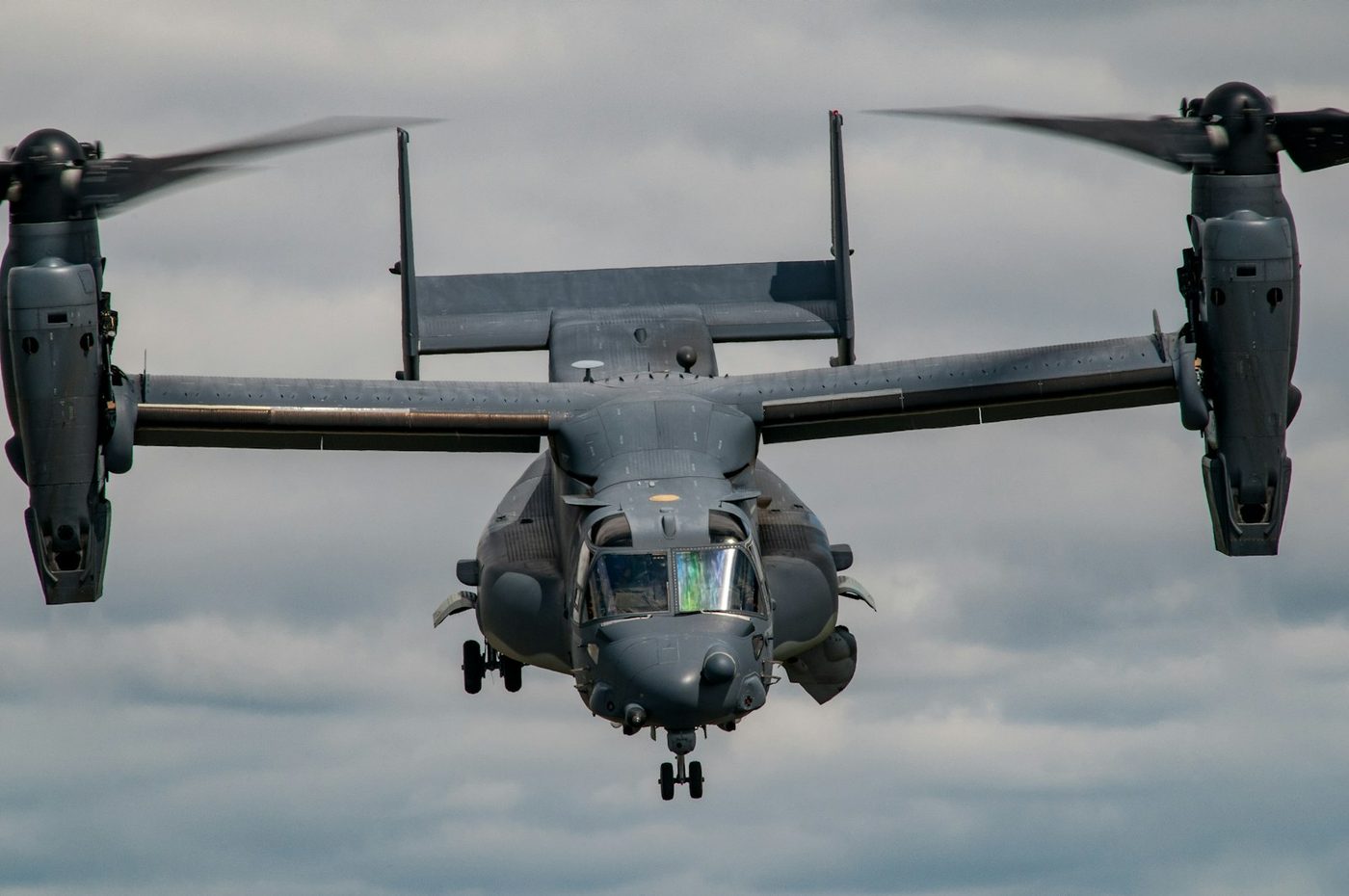 V-22 Osprey tiltrotor aircraft head-on against clouds
