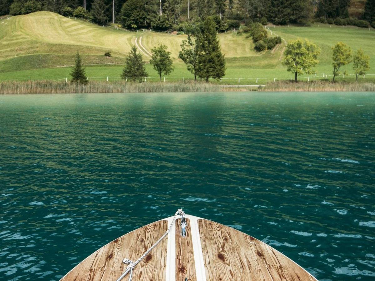Wooden boat bow gliding over clear teal water